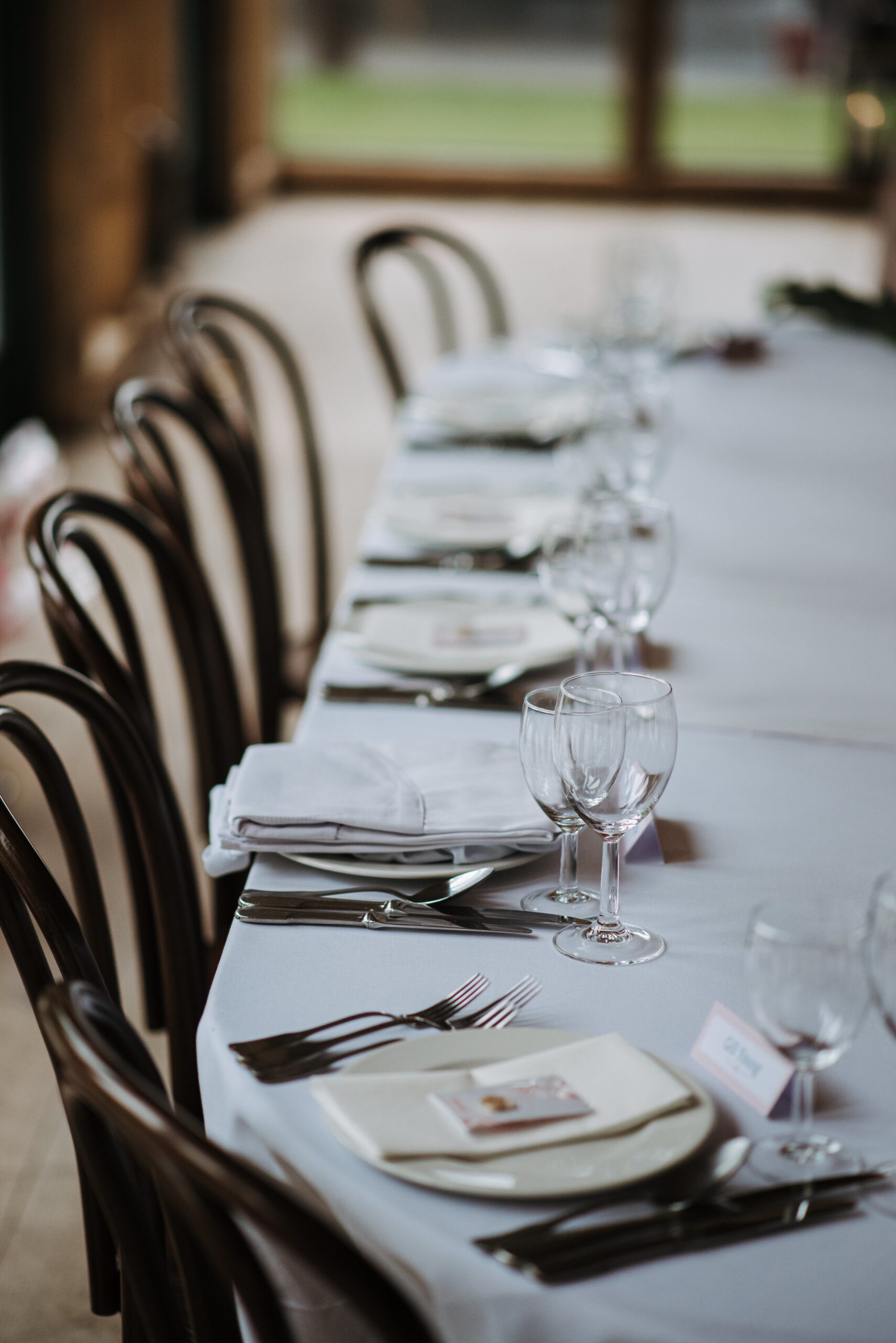 The wedding day's decorated table with plates, napkins, wine glasses, forks and knives